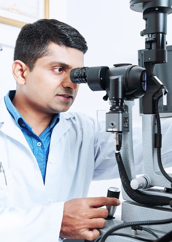 An optometrist examines a patient for a contact lens