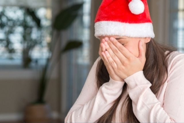 A girl wearing a festive Christmas cap playfully hides her eyes, creating a sense of mystery and excitement. The image sparks curiosity about holiday lights, prompting the question: 'Why do LED Christmas lights hurt human eyes?